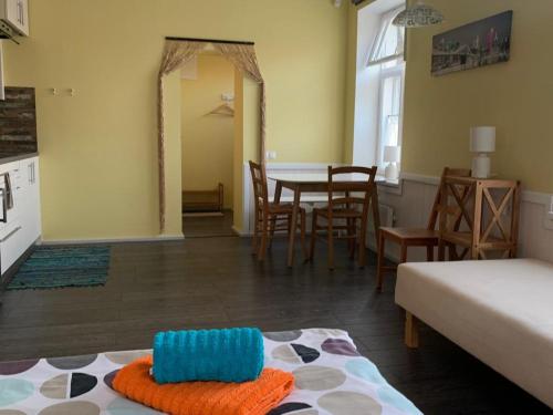 sala de estar con cama, mesa y sillas en Promenādes apartamenti, en Ventspils