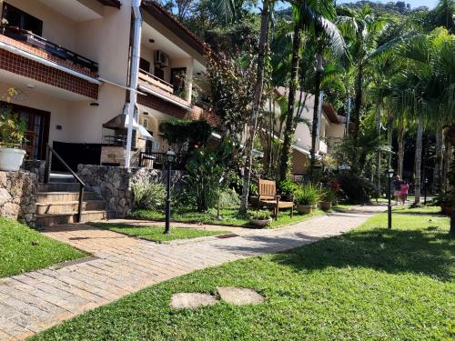 ein Gebäude mit Palmen und einem Gehweg in der Unterkunft Apartamento até 10 pessoas na enseada Guarujá em condomínio clube praia piscinas salão jogos quadra futebol campo parquinho brinquedos Wi-fi Home office in Guarujá