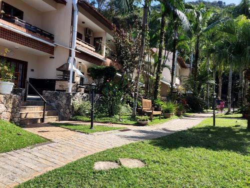 Κήπος έξω από το Apartamento até 10 pessoas na enseada Guarujá em condomínio clube praia piscinas salão jogos quadra futebol campo parquinho brinquedos Wi-fi Home office