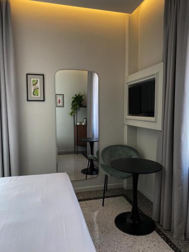 a hotel room with a bed and a table and a television at NoOne Tropea Guesthouse in Tropea