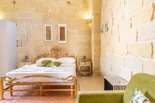 ein Schlafzimmer mit einem Bett und einer Ziegelwand in der Unterkunft ACAMYA LUXE Apartment in Acaya