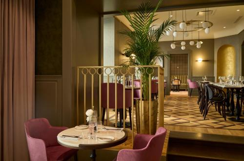 a restaurant with a table and chairs and a dining room at Hotel Saski Krakow Curio Collection by Hilton in Kraków