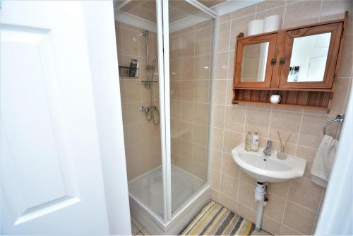 y baño con ducha y lavamanos. en Adorable 1 bedroom guest house with free parking., en Bromley