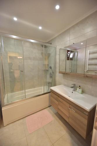 a bathroom with a shower and a sink and a tub at Caretta Apart in Fethiye