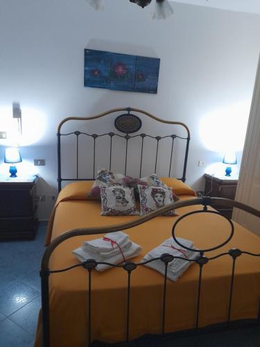 um quarto com uma cama com lençóis e almofadas amarelas em Casa Holiday em Caccamo