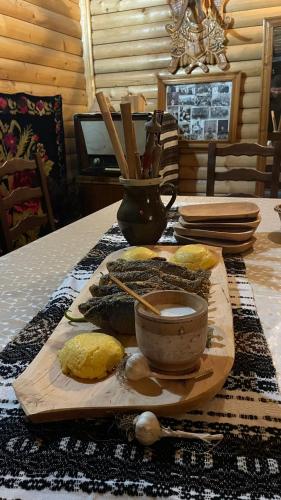 a table with a cutting board with a bowl of food at Casa de pe Deal in Sadova