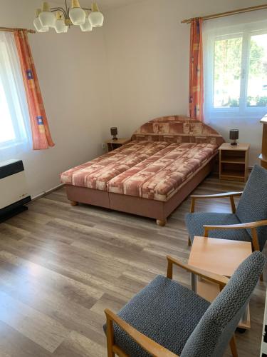 a bedroom with a bed and two chairs and a table at U Lokálky in Zadní Třebaň