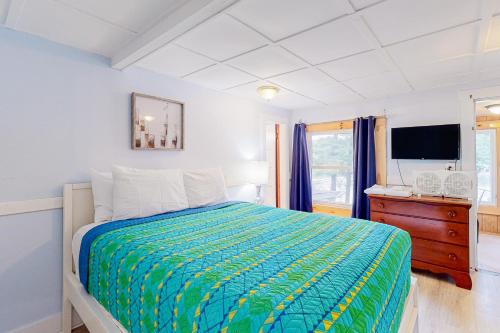 1 dormitorio con 1 cama, vestidor y TV en Cozy Lakefront Suite, en Standish