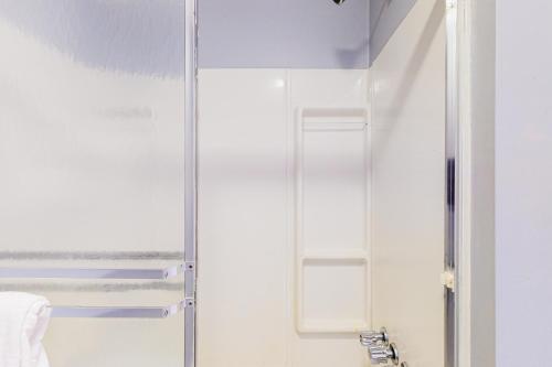 y baño con ducha y puerta de cristal. en Cozy Lakefront Suite, en Standish