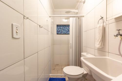a white bathroom with a toilet and a sink at BH Studios Hotel Brás in Sao Paulo