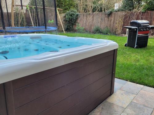 - un bain à remous dans la cour avec une poubelle dans l'établissement Villa L'Alameda Spa Billard Paris Centre 35min, à Verrières-le-Buisson