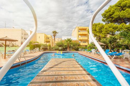 a pool at a resort with people swimming at Apartamentos El Oasis in Benicarló