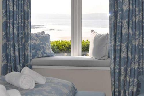 1 dormitorio con ventana y vistas al océano en Gorgeous Apartment only yards from Polzeath Beach en Wadebridge