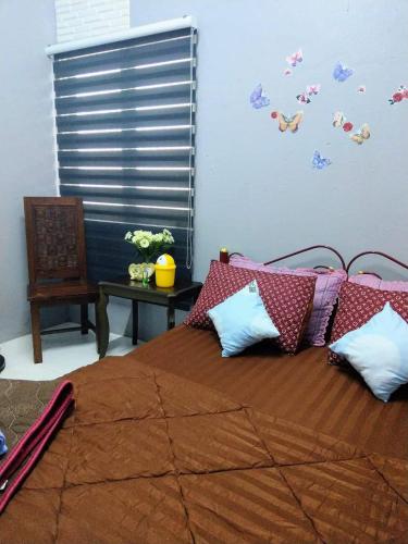 a bedroom with a large bed with pillows on it at Azie Homestay in Kota Bharu