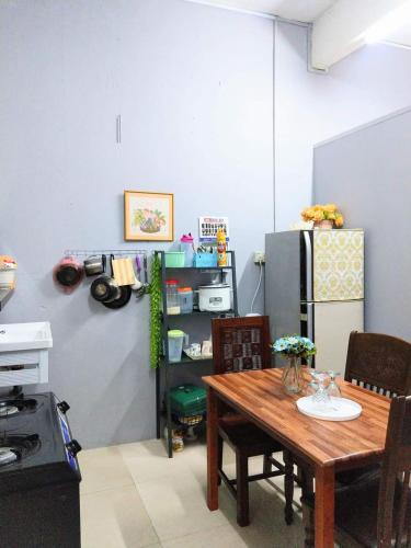 a kitchen with a table and a refrigerator at Azie Homestay in Kota Bharu