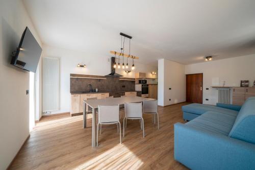 uma sala de estar com uma mesa e um sofá azul em Cauriol Suites 2.3 em Cavalese