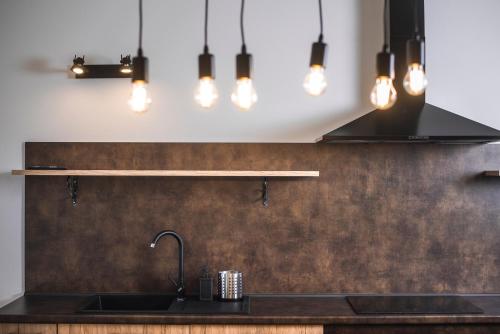 a kitchen with a sink and pendant lights at Cauriol Suites 2.3 in Cavalese