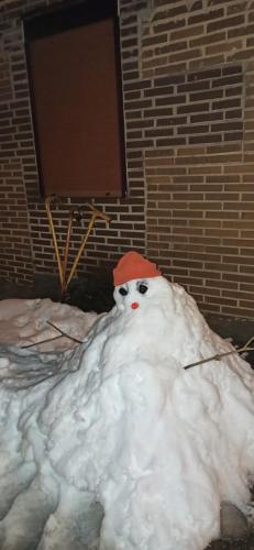 a snowman with a red hat on a pile of snow at Casa Manuel y Ana María. in Llombera