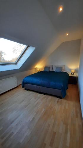 a bedroom with a blue bed in a attic at The Kettle House - Manor in Sint-Pieters-Leeuw