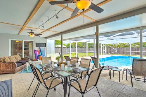 a living room with a table and chairs and a pool at Tropical Landing Stuart Home with Pool and Grill! in Stuart
