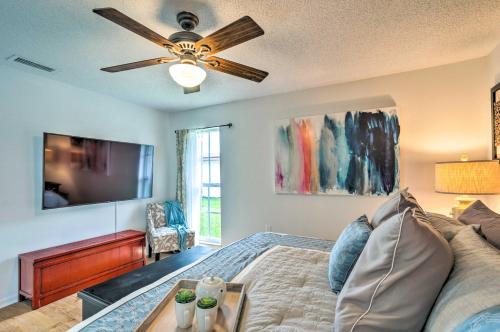 a living room with a bed and a ceiling fan at Tropical Landing Stuart Home with Pool and Grill! in Stuart
