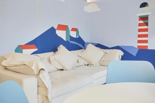 - un canapé blanc dans une chambre avec une fresque murale dans l'établissement Villa Ulisse - Suites - Luxury B&B, à Numana