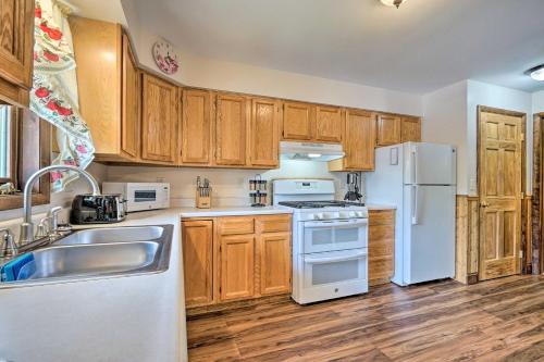 a kitchen with wooden cabinets and white appliances at Updated Bolton Home with Fire Pit! in Bolton