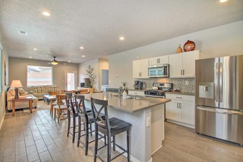 a kitchen with a bar with chairs and a dining room at Family-Friendly Rio Rancho Home Near Old Town in Rio Rancho