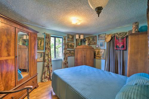 - une chambre avec un lit bleu et une armoire en bois dans l'établissement Arvada Bungalow - Walk to Olde Town Arvada!, à Arvada