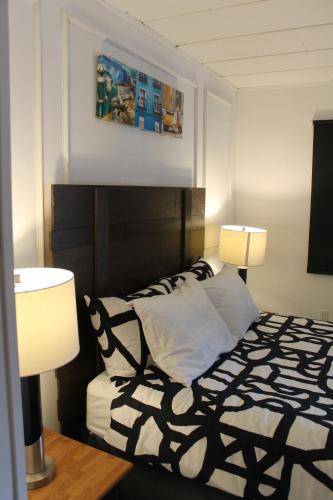 a bedroom with a black and white bed with two lamps at Sage Hills Motel in Cache Creek