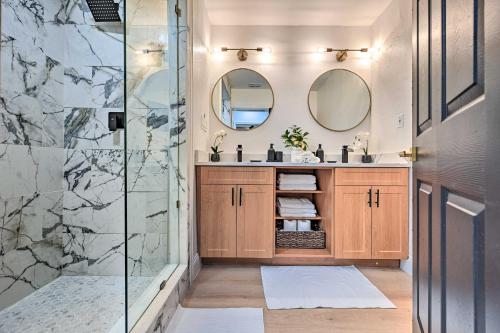 uma casa de banho com um chuveiro e um lavatório com 2 espelhos em All-Encompassing Retreat with Pool and Game Room! em Tampa