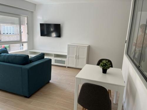 ein Wohnzimmer mit einem blauen Sofa und einem Tisch in der Unterkunft Apartamentos 23 in Tui