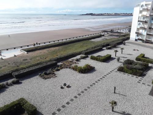 a view of the beach from the balcony of a building at Appartement fonctionnel, vue imprenable mer in Saint-Gilles-Croix-de-Vie