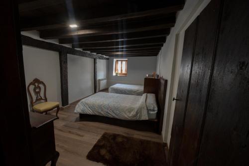 um pequeno quarto com uma cama e uma cadeira em Mujika Etxea em Manurga