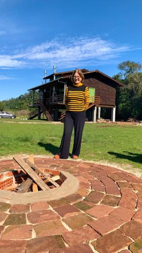a woman standing on top of a brick patio at Hospedagem Bela Roça - Lareira, Passeio a cavalo, ovelhas in Bom Princípio