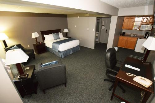 a hotel room with a bed and a desk and chair at Lakeland Inn Hotel in Cold Lake