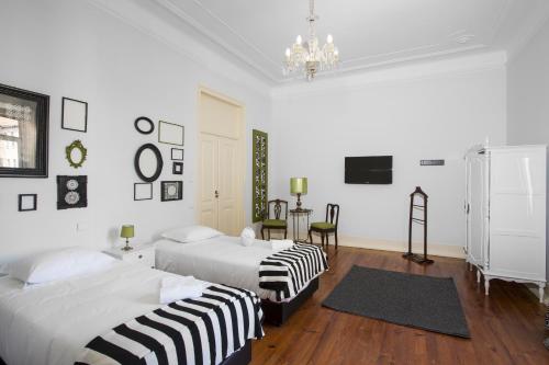a bedroom with two beds and a chandelier at Typical Lisbon Guest House in Lisbon