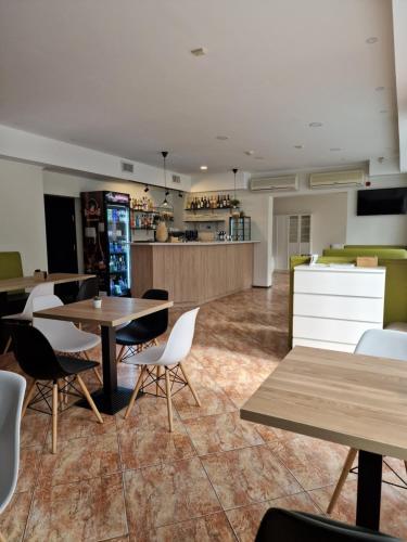 Guest House KAKTUS في ريغا: غرفة بها طاولات وكراسي ومطبخ