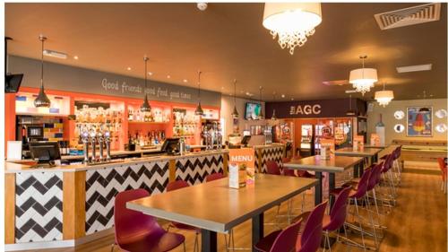 a restaurant with tables and chairs and a bar at Willow-Static Caravan on Holiday Park near Margate, Kent in Kent