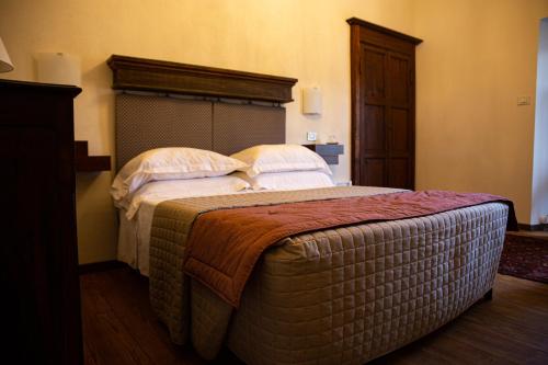 a bedroom with a large bed with pillows on it at Maison Flipot in Torre Pellice