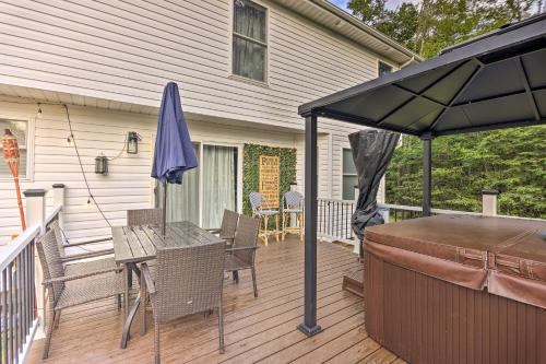 a patio with an umbrella and a table and chairs at Hot Tub and Fire Pit Family Home in Tobyhanna in Tobyhanna