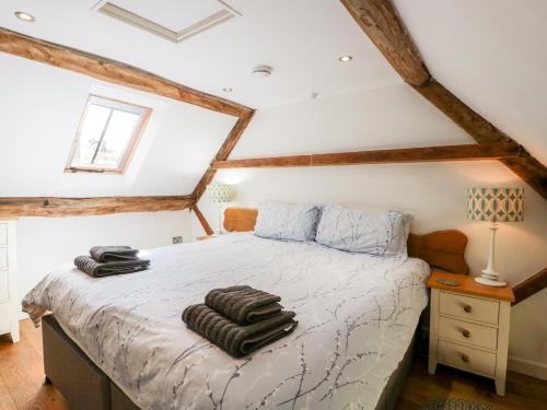 1 dormitorio con 1 cama con toallas en Tump Cottage en Nympsfield