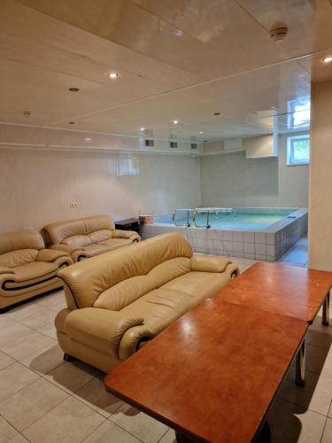 ein Wohnzimmer mit einem Sofa, einem Tisch und einem Pool in der Unterkunft Guest House KAKTUS in Riga