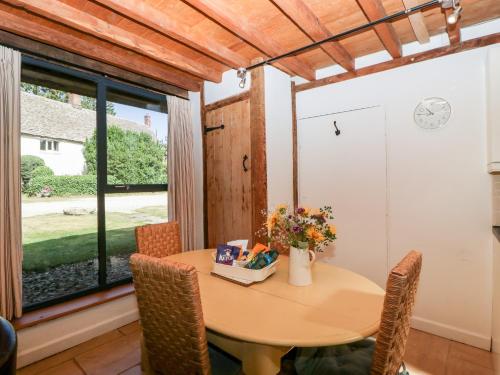 a dining room with a table and a window at Nympy Cottage in Nympsfield