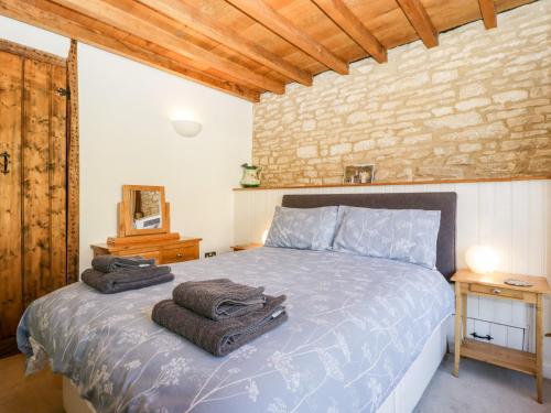 a bedroom with a bed with towels on it at Nympy Cottage in Nymphsfield