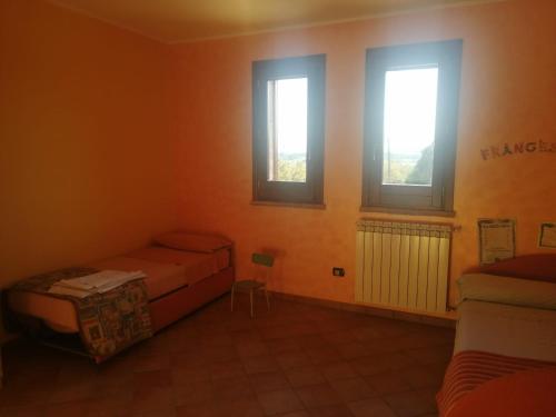 um quarto com 2 camas e 2 janelas em Villa Di Caro em Ravanusa