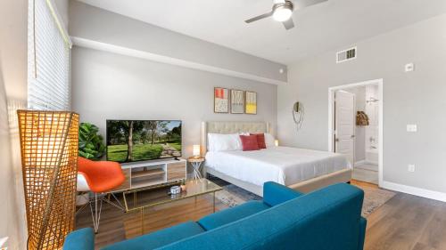 a bedroom with a bed and a tv and a couch at Upscale Modern Apts - Free Parking, Fast WiFi, Courtyard in Austin