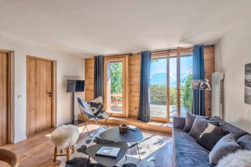 un salon avec un canapé et une table dans l'établissement Appartement Vue Montagnarde - Welkeys, à Combloux