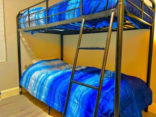 1 dormitorio con 1 litera con sábanas azules en STOP Inn STAY HOSTEL, en Houston