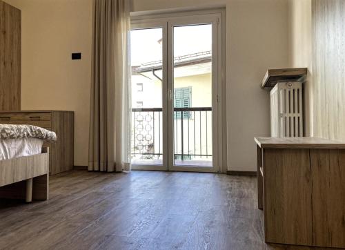 a bedroom with a large sliding glass door with a balcony at Cauriol Suites 2.3 in Cavalese